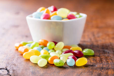 Sweet colorful jelly beans on wooden table.
