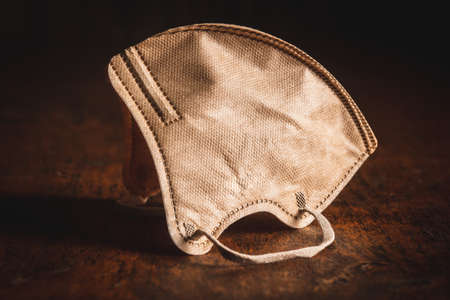 KN95 respirator mask for  virus protection. Brown face mask protects against   infection on wooden table.の写真素材