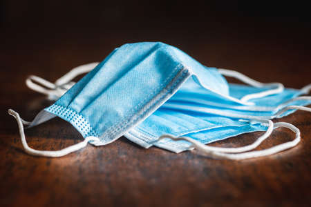 Surgical mask for   protection. Face mask protects against infection on wooden table.