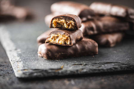 Chocolate bars with nuts filling on black table.の写真素材