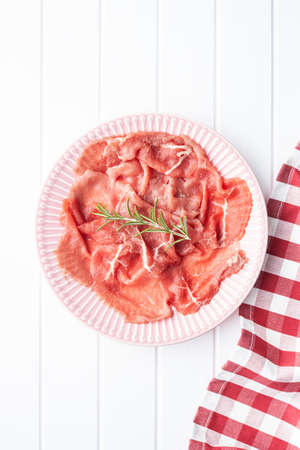 Sliced carpaccio. Raw beef meat on plate. Top view.の写真素材