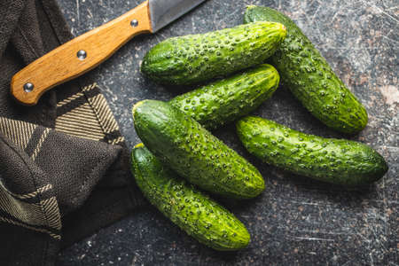 Fresh green cucumbers on black kitchen table. Top view.の写真素材