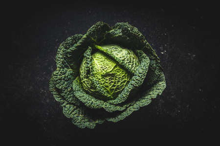 Green savoy cabbage on black table. Top view.の写真素材