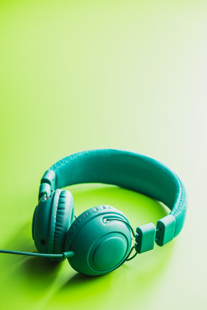 Green wired stereo headphones on green background.の写真素材