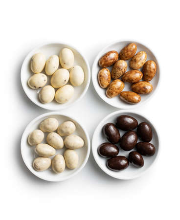Sweet chocolate almonds in bowl. Chocolate eggs isolated on white background.の写真素材