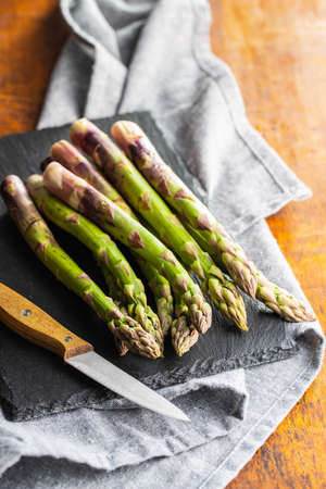 Fresh raw uncooked green asparagus on cuttting board.の写真素材