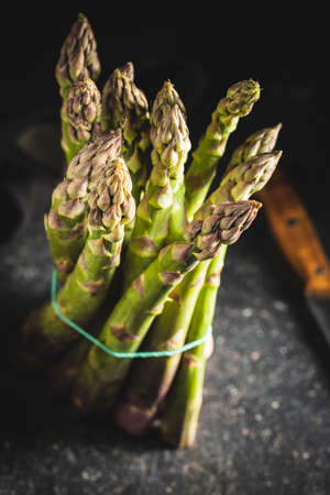 Fresh raw uncooked green asparagus on black table.の写真素材