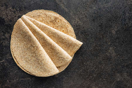 Whole grain tortilla wraps on black table.の写真素材