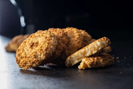 Sweet coconut cookies. Tasty biscuits with coconut flavor on black table.の写真素材