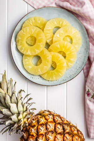 Canned sliced pineapple fruit on plate. Top view.