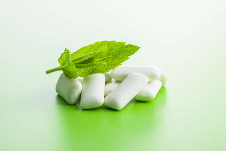 Mint chewing gum pads and mint leaves on green background.の写真素材