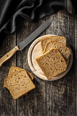 Sliced wholegrain bread on wooden table. Top view.