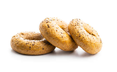 Whole grain baked bagel isolated on white background.