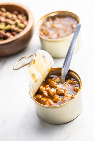 Canned pet food. Tasty food for dog or cat on white table.