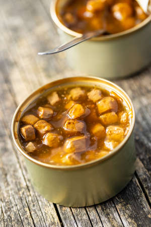Canned pet food. Tasty food for dog or cat on wooden table.