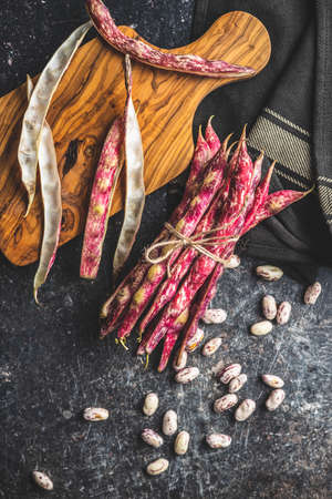 Cranberry beans. Beans pods on a black table. Top view.