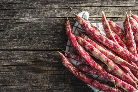 Cranberry beans. Borlotti beans. Beans pods on wooden table. Top view.の写真素材