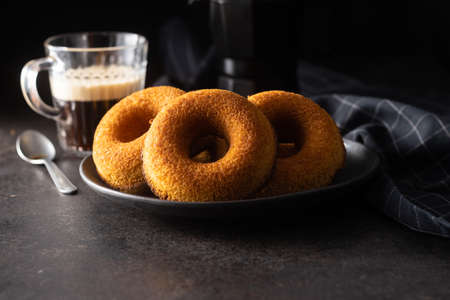 Round sponge cake dessert. Sweet donut on black table.