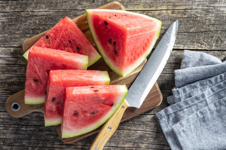 Red sliced watermelon. Pieces of red melon on cutting board. Top view.の写真素材