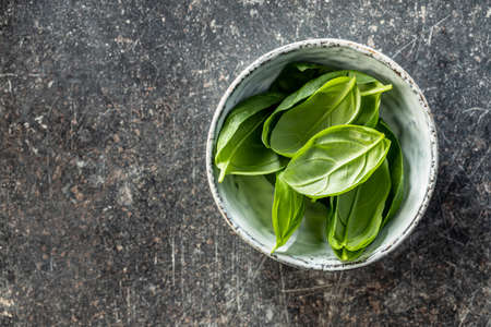 Fresh green basil leaves in bowl. Top view.の写真素材
