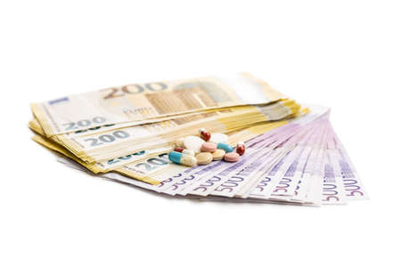 Euro banknotes and pills isolated on white background.の写真素材