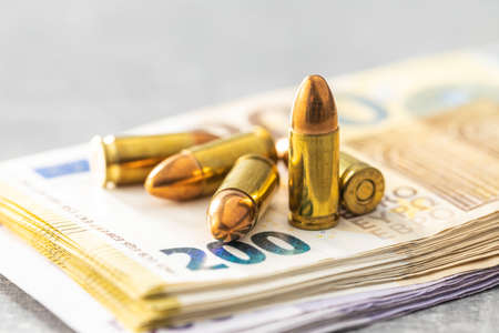 Euro banknotes and bullets on gray table.の写真素材