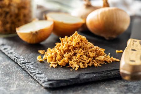 Pieces of fried onions on cutting board.の写真素材