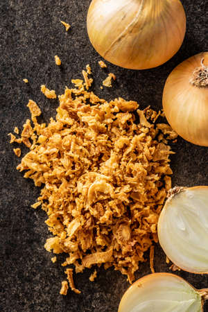 Pieces of fried onions on black table. Top view.の写真素材