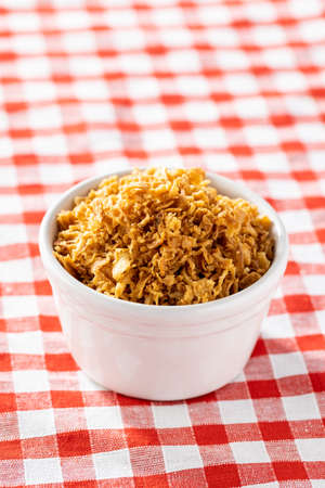 Pieces of fried onions in bowl on checkered napkin.の写真素材