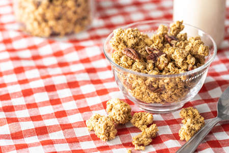 Sweet granola cereals in bowl on checkered napkin.