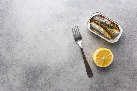 Canned sardines. Sea fish in tin can on kitchen table. Top view.の写真素材