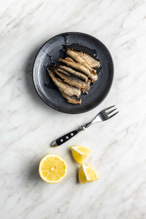 Smoked sprats on plate. Canned sea fish. Top view.の写真素材