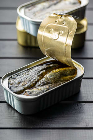 Canned sardines. Sea fish in tin can on black table.の写真素材