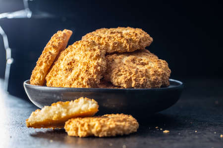 Sweet coconut cookies. Tasty biscuits with coconut flavor on black table.の写真素材