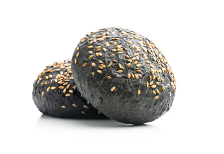 Black bun. Dark pastry with sesame seeds isolated on white background.の写真素材