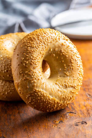 Baked bagel with sesame seeds on wooden table.の写真素材