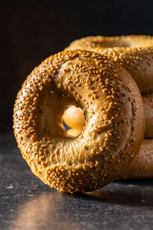 Baked bagel with sesame seeds on black table.の写真素材