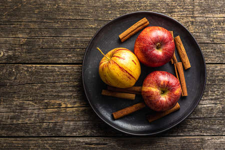 Fresh autumn apples on plate on wooden table. Top view.の写真素材
