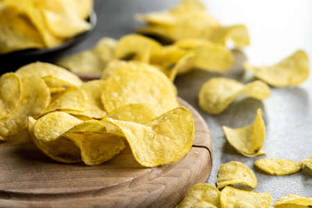 Crunchy potato chips. Potato crisps on cutting board.