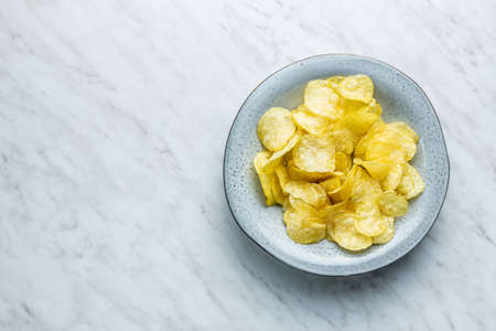 Crunchy potato chips. Potato crisps in plate. Top view.の写真素材