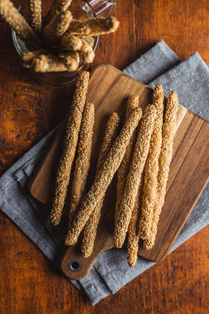 Breadsticks grissini. Bread sticks with sesame seeds on wooden table. Top view.の写真素材