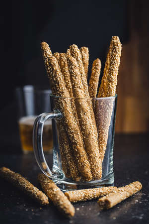 Breadsticks grissini. Bread sticks with sesame seeds on black table.の写真素材