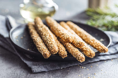 Breadsticks grissini. Bread sticks with sesame seeds on plate.の写真素材