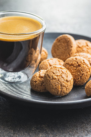 Amaretti biscuits. Sweet italian almond cookies and coffee cup on kitchen table.の写真素材