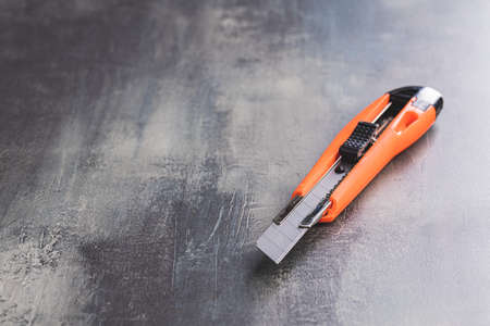 Plastic orange utility knife on table.の写真素材