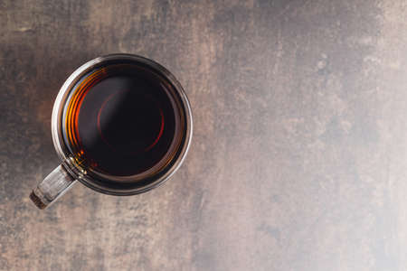 Tea in glass cup on old table. Top view.