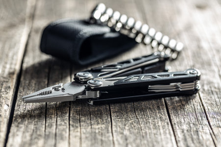 Multi-tools pliers with other tools and knife. Multifunction pliers on wooden table.の写真素材