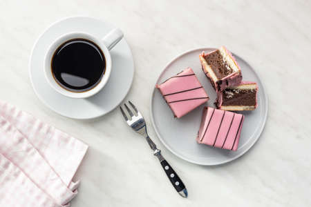 Sweet cake and coffee mug. Pink tasty dessert on plate. Top view.の写真素材
