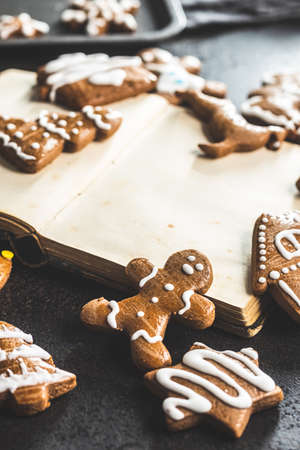 Homemade sweet christmas gingerbread cookies and cookbook on black table.の写真素材