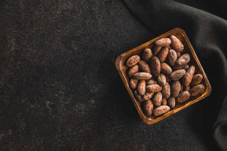 Dried cocoa beans. Cacao beans in bowl. Top view.